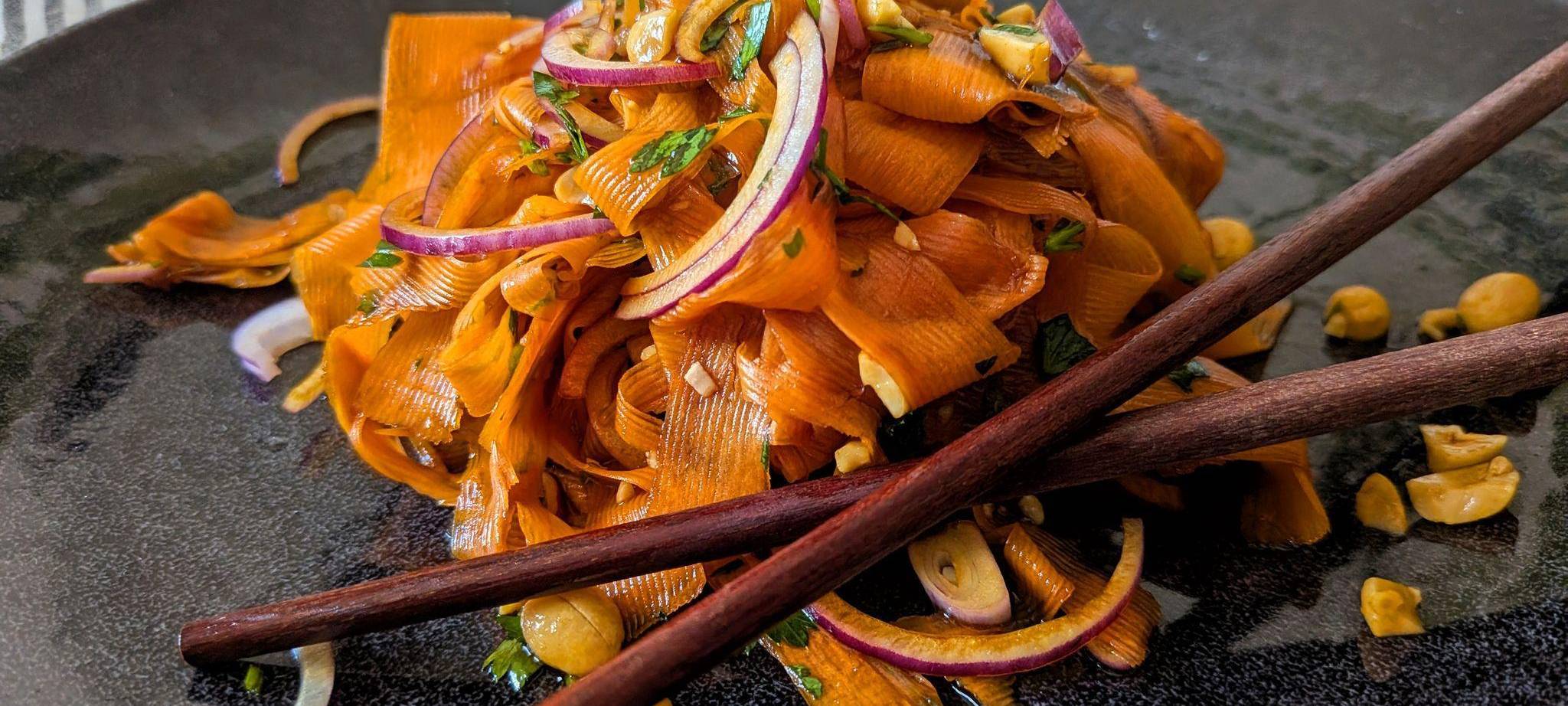 Ein Teller mit Karottensalat im Asia-Style steht auf dem Tisch