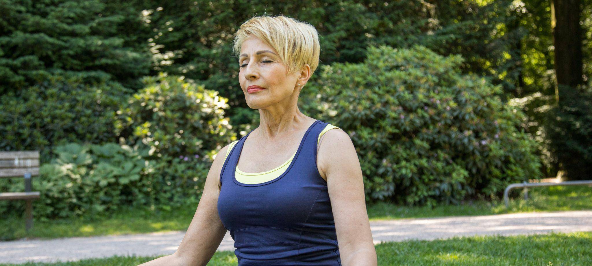 Frau macht Yoga-Übungen im Park